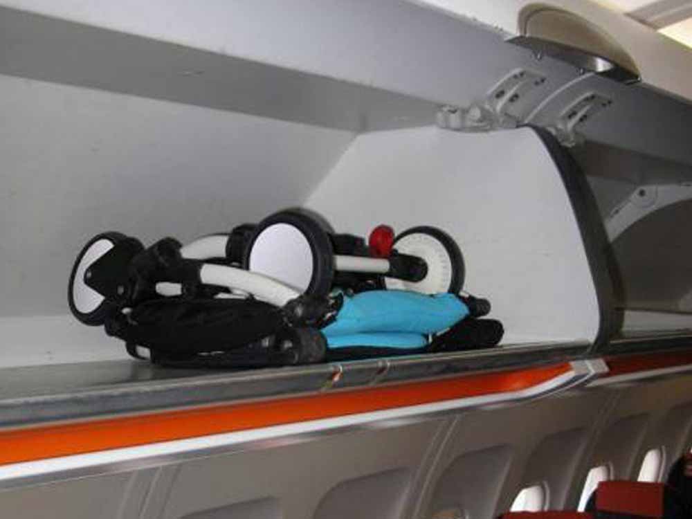 YOYO Babyzen 6+passeggino piegato nella cabina valigia del compartimento di un aereo